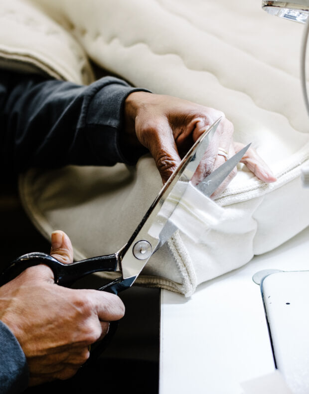 Obasan's factory worker trimming a mattress' zipper